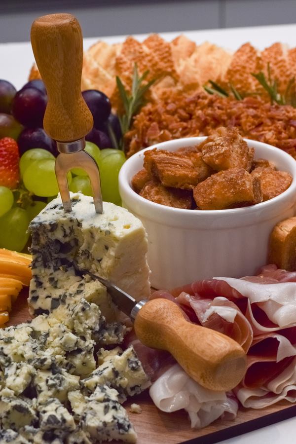 Tábua de frios com gorgonzola, presunto cru, uvas e torradas
