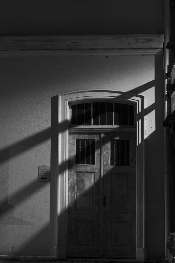 Sombra oculta: porta antiga em preto e branco, cortada pelas sombras da janela